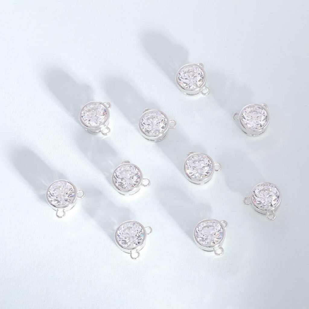 Ten bezel-set round brilliant stones in polished silver-tone settings, arranged on a white surface